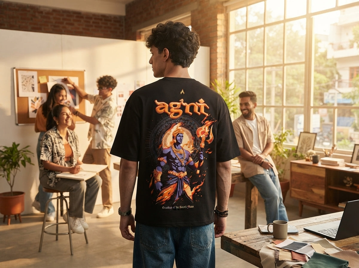 A group of diverse young Indian adults in a creative studio, focusing on a person wearing an Agni oversized puff print t-shir